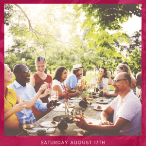 People sitting outside at a table, laughing, drinking around food.